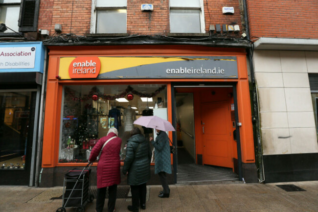 dublin-ireland-07th-november-2025-capel-street-as-a-group-of-old-women-stand-with-an-umbrella-outside-an-enable-ireland-charity-shop-in-dublin-city-on-an-overcast-afternoon-depicting-a-street-sce