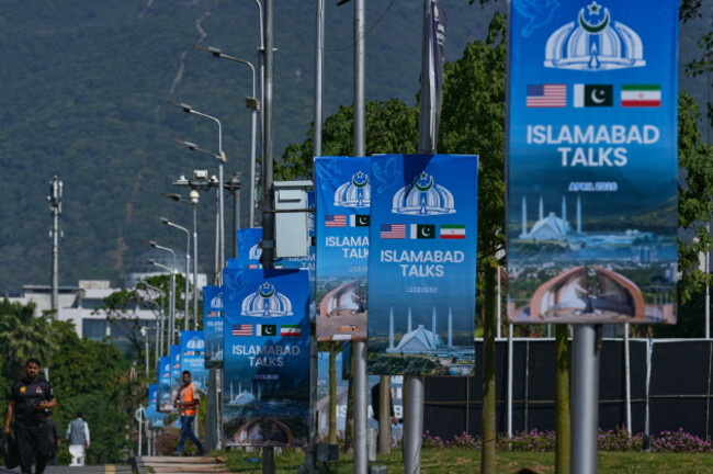 workers-walk-past-billboards-near-the-serena-hotel-ahead-of-the-second-round-of-negotiations-between-the-u-s-and-iran-in-islamabad-pakistan-monday-april-20-2026-ap-photoanjum-naveed