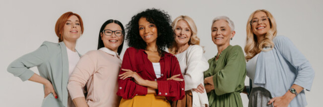 group-of-elegant-mature-women-bonding-and-smiling-against-grey-background