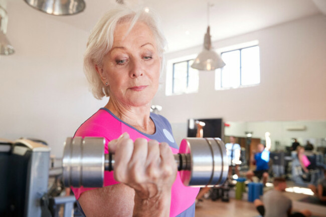 senior-woman-exercising-with-weights-in-gym