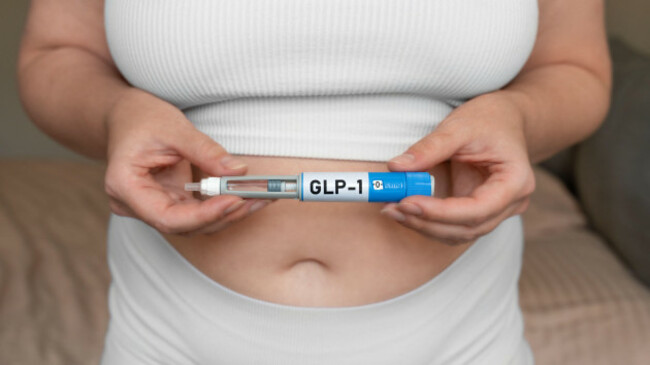 glp-1-injection-pen-in-female-hands-near-abdomen-weight-loss-and-diabetes-treatment-concept