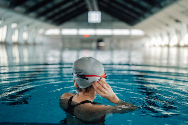 femaleswimmeradjustingherswimcapandadjustinghergoggles
