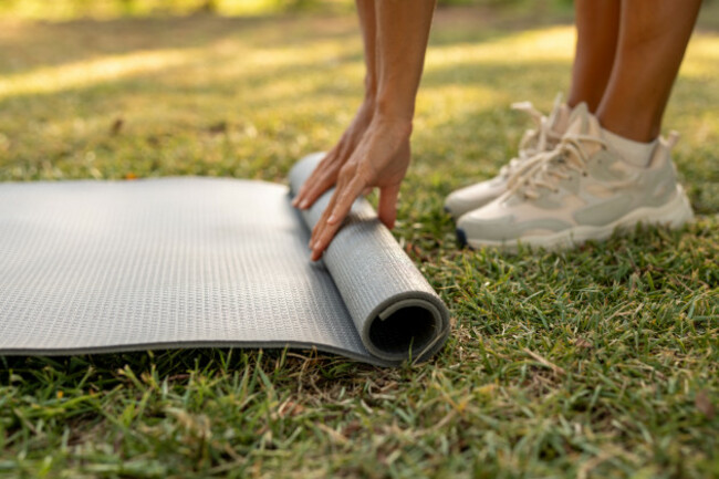 close-upofhandsrollingoutayogamatonthe
