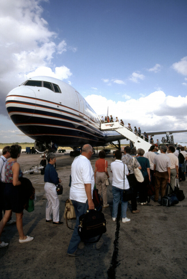plane-passengers-with-hand-luggage-queuing-to-board-britannia-jet-airliner-flight-to-uk-1980s-view-santo-domingo-airport-dominican-republic-caribbean-image-shot-1998-exact-date-unknown