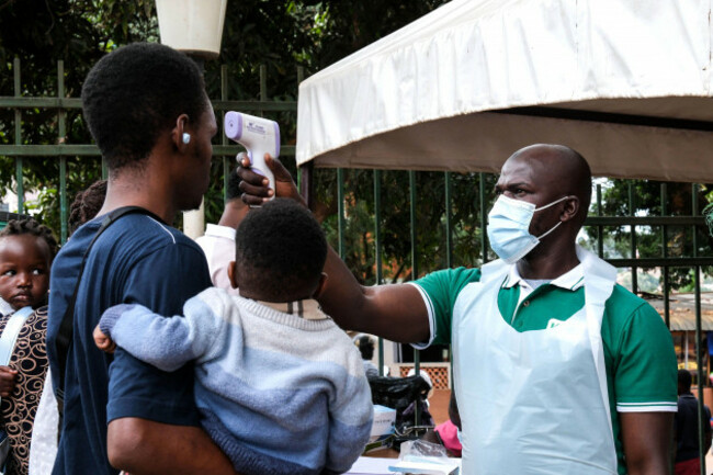 a-health-official-uses-a-thermometer-to-screen-people-in-front-of-kibuli-muslim-hospital-in-kampala-uganda-saturday-may-16-2026-ap-photo-hajarah-nalwadda