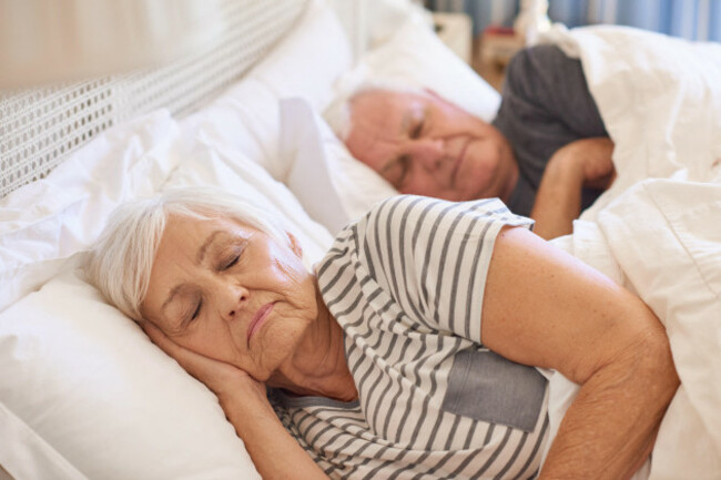 senior-couple-asleep-in-their-bed-at-home