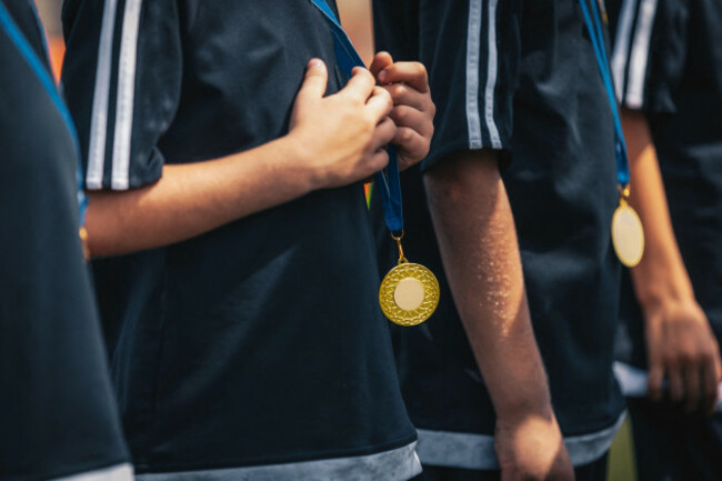 sports-kids-players-with-golden-medals-standing-in-a-row-during-celebration-medals-hanging-around-young-sport-players-necks