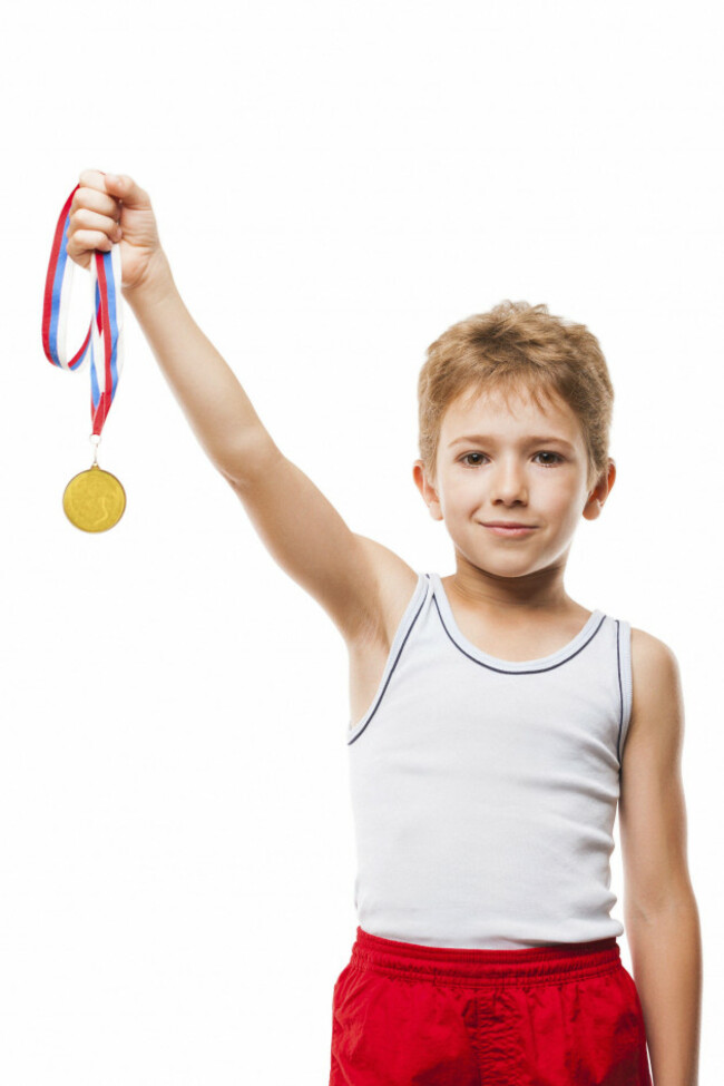 sport-success-and-win-concept-smiling-athlete-champion-child-boy-hand-holding-first-place-victory-gold-medal-award