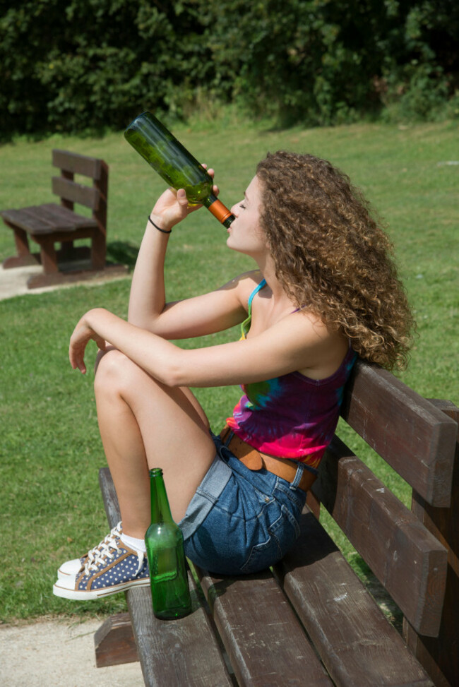 teenage-girl-drinking-alcohol-on-a-park-bench