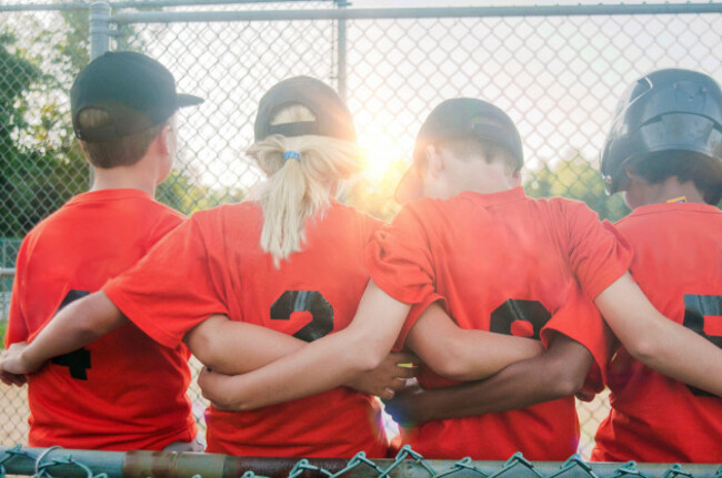 a-10-year-old-girl-with-her-teammates-in-the-dugout