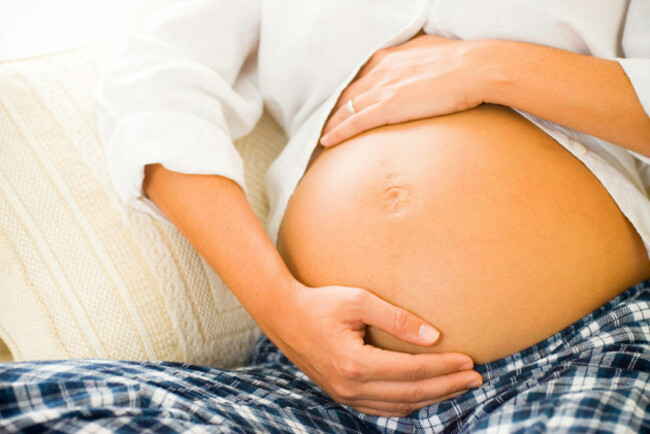 portrait-of-pregnant-belly-of-pregnant-woman-sitting-on-couch