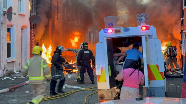 a-family-get-into-a-psni-vehicle-after-being-rescued-from-houses-which-caught-fire-in-lendrick-street-in-east-belfast-as-disorder-flared-in-response-to-monday-nights-stabbing-attack-in-the-city-a-3