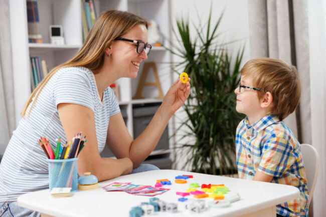 woman-and-boy-engaging-in-educational-activity-at-table-with-colorful-learning-materials