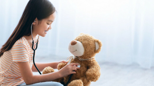 child-practices-doctor-role-with-teddy-bear-in-cozy-indoor-space-during-daytime