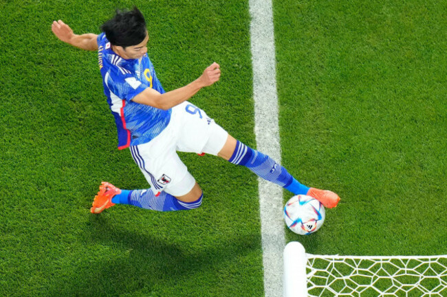 japans-kaoru-mitoma-appears-to-have-the-ball-over-the-line-before-crossing-it-for-a-goal-during-the-world-cup-group-e-soccer-match-between-japan-and-spain-at-the-khalifa-international-stadium-in-doh
