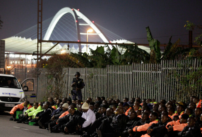 a-policeman-stands-over-detained-protesters-in-front-of-the-moses-mabhida-world-cup-stadium-after-a-protest-in-durban-south-africa-early-monday-june-14-2010-armed-riot-police-charged-into-hundreds