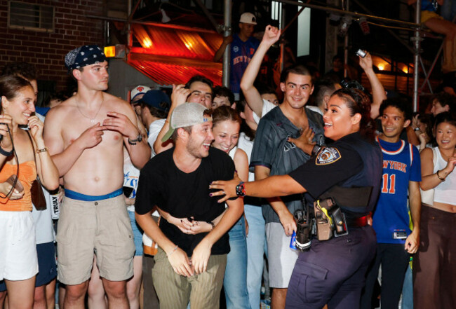 new-york-united-states-14th-june-2026-an-nypd-police-officer-contains-new-york-knicks-fans-celebrating-on-the-street-on-st-marks-place-after-the-knicks-victory-in-game-five-of-the-nba-finals-in-s