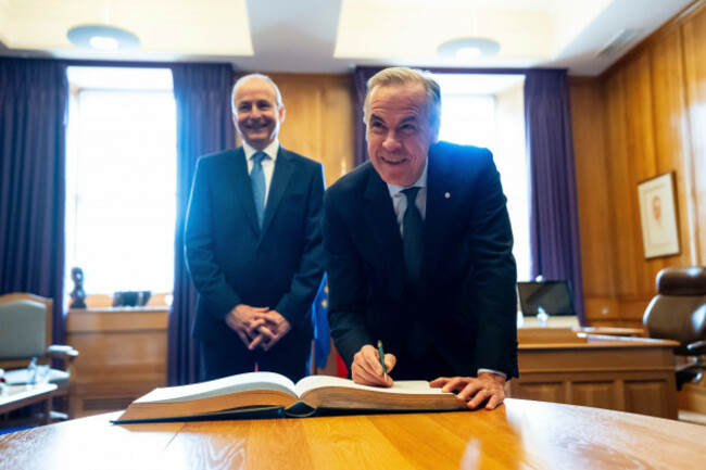 prime-minister-mark-carney-signs-the-guest-book-as-micheal-martin-irelands-head-of-government-looks-on-at-the-government-buildings-in-dublin-on-saturday-june-13-2026-christopher-katsarov-the