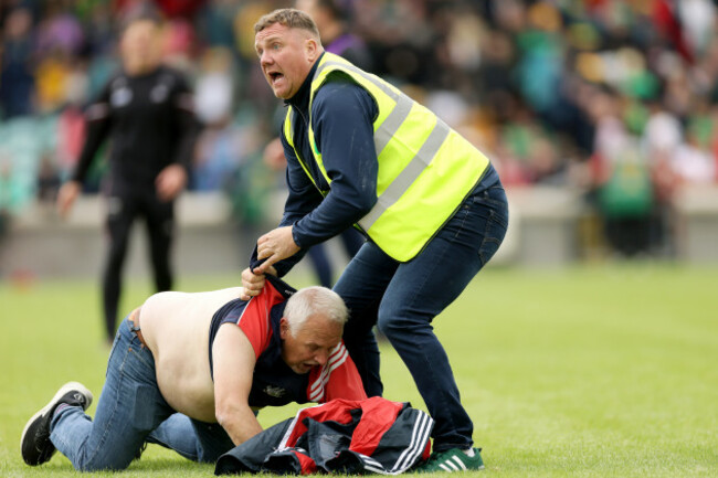 a-steward-tackles-a-cork-fan-on-the-pitch-after-the-game