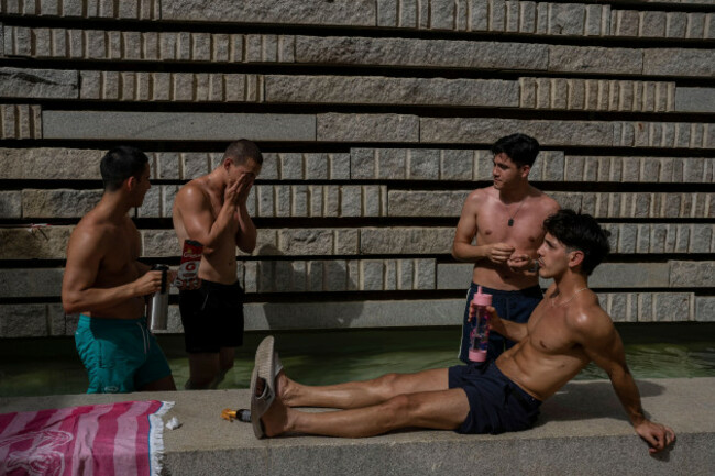 men-cool-off-in-a-fountain-in-a-park-by-the-river-in-madrid-spain-wednesday-june-15-2022-spains-weather-service-says-a-mass-of-hot-air-from-north-africa-is-triggering-the-countrys-first-major-h