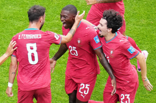 portugals-nuno-mendes-25-reacts-with-teammates-portugals-bruno-fernandes-8-and-portugals-vitinha-23-after-scoring-his-teams-second-goal-during-the-world-cup-group-k-soccer-match-between-port