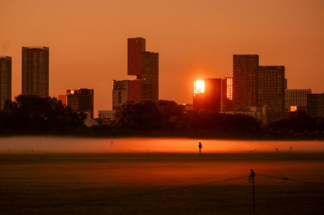view-of-hackney-marshes-london-covered-in-mist-during-the-summer-solstice-in-the-early-hours-of-the-morning-on-21-june-2026-crowds-gathered-in-the-park-to-watch-the-sunrise-against-the-backdrop-of