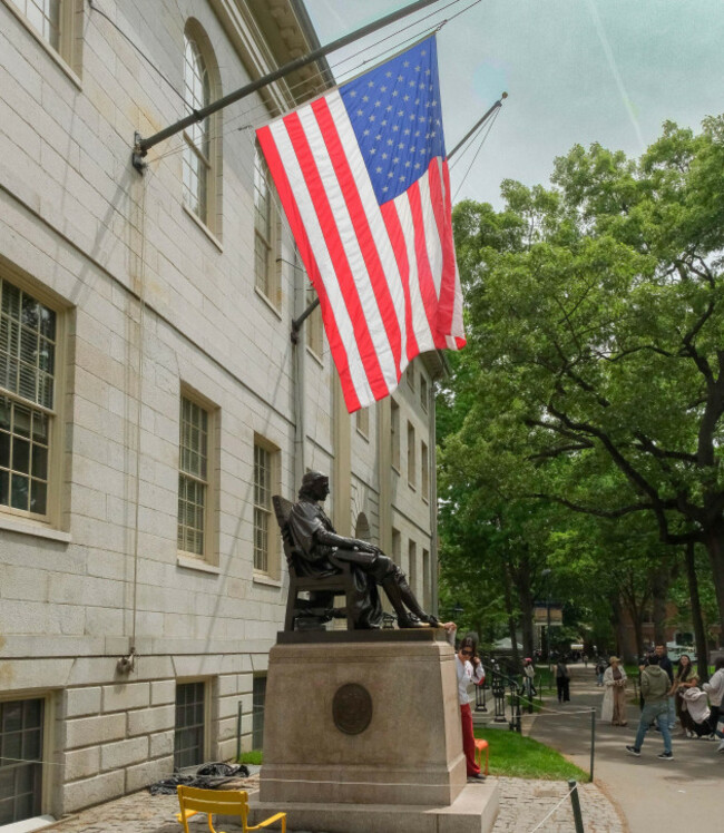 may-22-2026-cambridge-massachusetts-usa-visitors-gather-by-the-statue-of-john-harvard-the-namesake-for-harvard-university-so-honored-for-his-bequest-that-helped-start-the-university-it-is-loca