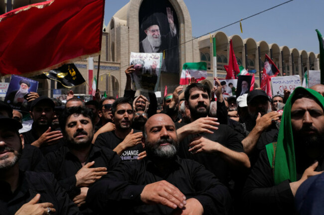 mourners-beat-their-chests-as-they-attend-the-dayslong-funeral-ceremonies-for-the-late-iranian-supreme-leader-ayatollah-ali-khamenei-shown-in-banner-at-rear-and-members-of-his-family-at-the-imam-kho