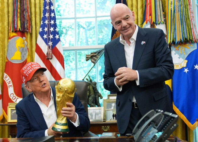 file-president-donald-trump-holds-the-fifa-world-cup-winners-trophy-as-fifa-president-gianni-infantino-looks-on-during-an-announcement-in-the-oval-office-of-the-white-house-aug-22-2025-in-washin
