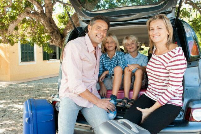 family-sitting-together-in-back-of-car-with-open-hatchback