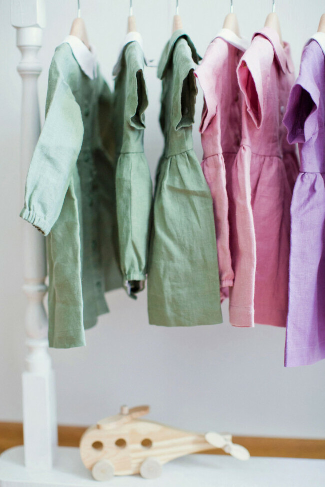 colorful-dresses-hanging-on-rack-in-front-of-wall