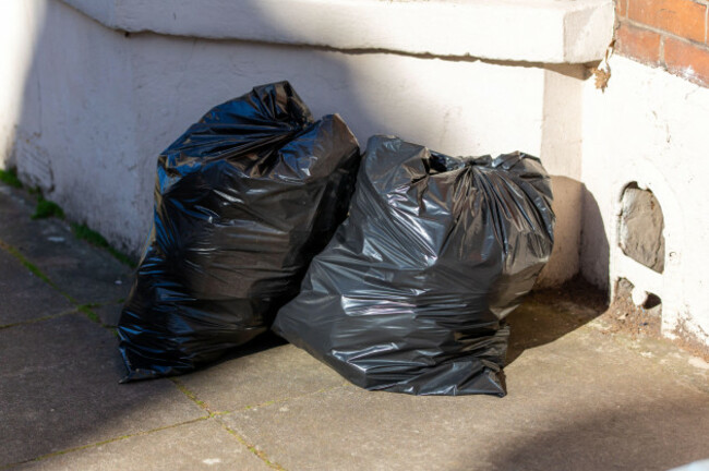 two-full-black-rubbish-bags-or-black-bin-bags-outside-a-house-ready-for-bin-collection
