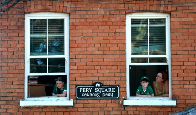 fans-looks-on-from-their-window-during-the-homecoming