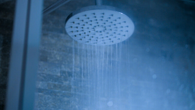 contemporary-design-of-round-chrome-shower-head-with-running-water-in-bathroom