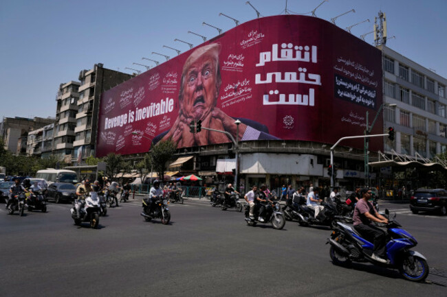 motorcyclists-ride-past-a-billboard-depicting-u-s-president-donald-trump-with-hands-around-his-neck-alongside-the-message-revenge-is-inevitable-in-english-and-farsi-in-tehran-iran-monday-july-2