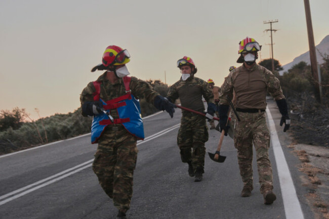 firefighters-walk-along-a-road-carrying-firefighting-tools-during-a-wildfire-in-the-rethymno-region-on-the-southern-greek-island-of-crete-wednesday-july-29-2026-where-two-firefighters-died-while-b