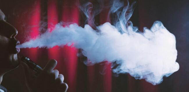 young-man-vaping-clouds-on-a-dark-background-useful-for-vaping-shops