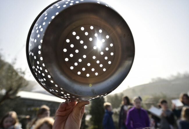 eds-note-solar-filter-has-been-used-people-watch-the-eclipse-of-the-sun-through-a-colander-over-the-eden-project-near-st-austell-in-cornwall
