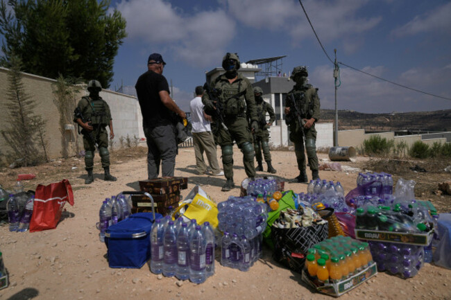 activists-accumulate-food-and-water-supplies-in-front-of-israeli-army-soldiers-who-are-blocking-the-road-leading-to-the-houses-of-three-palestinian-families-that-have-been-besieged-by-israeli-settlers