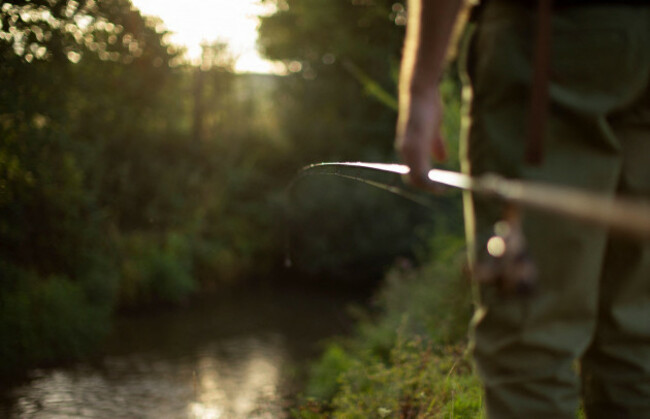 man-with-fly-fishing-pole-at-sunny-riverbank