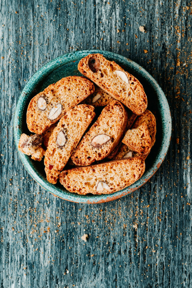 high-angle-view-of-a-green-earthenware-plate-with-some-carquinyolis-almond-biscuits-typical-of-catalonia-spain-similar-to-italian-biscotti-on-a-gr