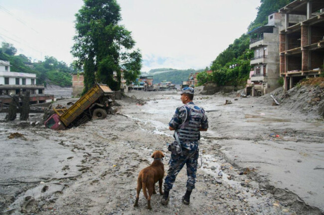 a-policeman-with-a-sniffer-dog-looks-at-the-damage-in-the-aftermath-of-flash-floods-in-devighat-in-the-nuwakot-district-in-nepal-thursday-aug-27-2026-ap-photoniranjan-shrestha