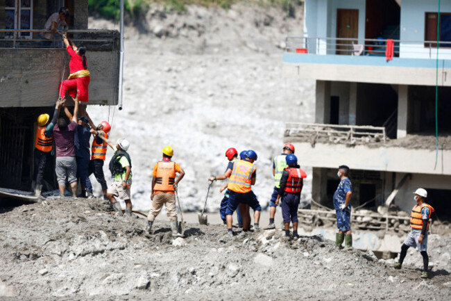 nuwakot-nepal-28th-aug-2026-a-woman-climbs-on-top-of-her-home-to-retrieve-goods-following-flash-floods-at-devighat-in-bidur-municipality-nuwakot-district-nepal-on-thursday-august-27-2026-the