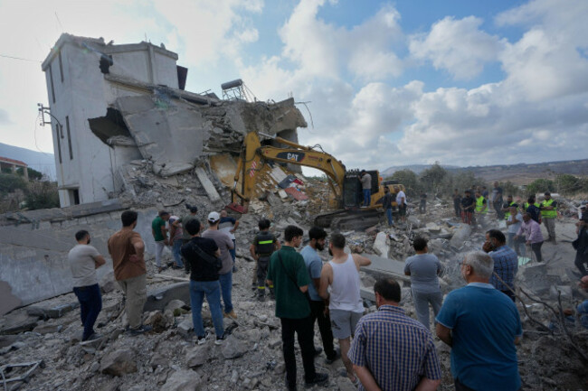 people-watch-rescue-workers-use-an-excavator-as-they-conduct-a-search-operation-at-a-destroyed-house-that-was-hit-by-an-israeli-airstrike-in-arab-salim-village-southern-lebanon-sunday-sept-6-2026