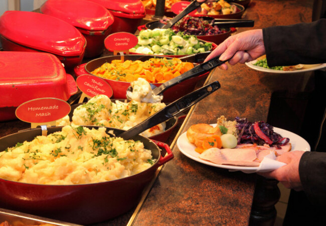 loading-a-plate-with-vegetables-and-gravy-at-a-toby-carvery-pub