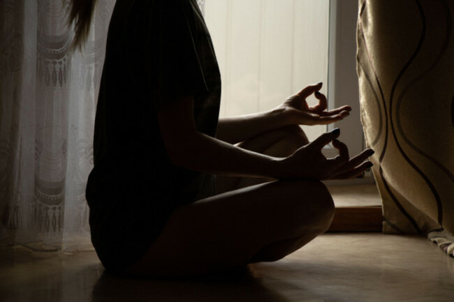 the-girl-meditates-in-the-apartment-sitting-on-the-floor-near-the-window-yoga-and-meditation-at-home