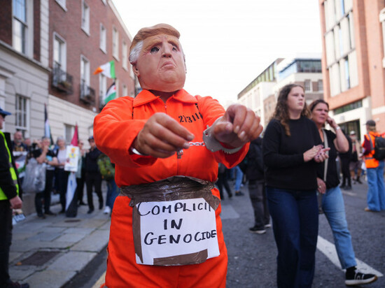 a-person-wearing-a-donald-trump-mask-and-dressed-in-an-orange-prison-style-jumpsuit-and-in-handcuffs-at-an-anti-trump-protest-march-through-dublin-city-centre-during-us-president-donald-trumps-trip