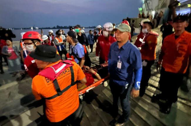 in-this-photo-taken-with-a-smartphone-rescuers-carry-a-survivor-on-a-stretcher-after-a-ferry-sank-in-bad-weather-in-the-java-sea-upon-arrival-at-a-port-in-banjarmasin-south-kalimantan-indonesia-s