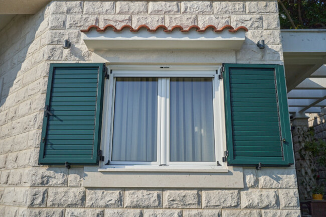 whitewindowinahousewithopenplasticshutters