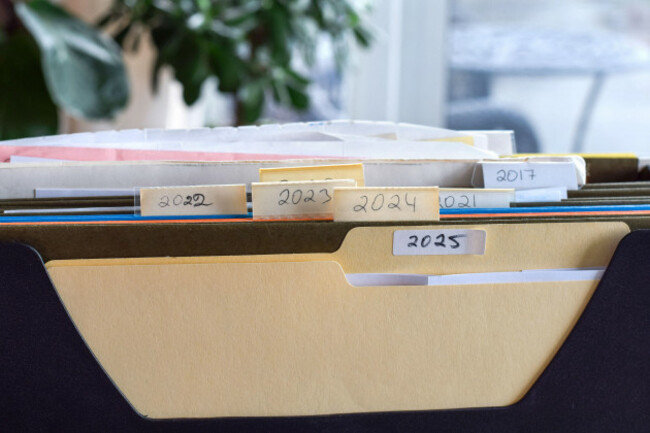 file-holder-filled-with-multiple-folders-containing-previous-years-tax-documents-organized-paperwork-system-highlighting-financial-records-archiving